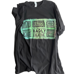 Black custom t-shirt with green and black geometric design and 'Badly Creative' logo, printed in San Francisco by Badly Creative Custom Apparel Printing.